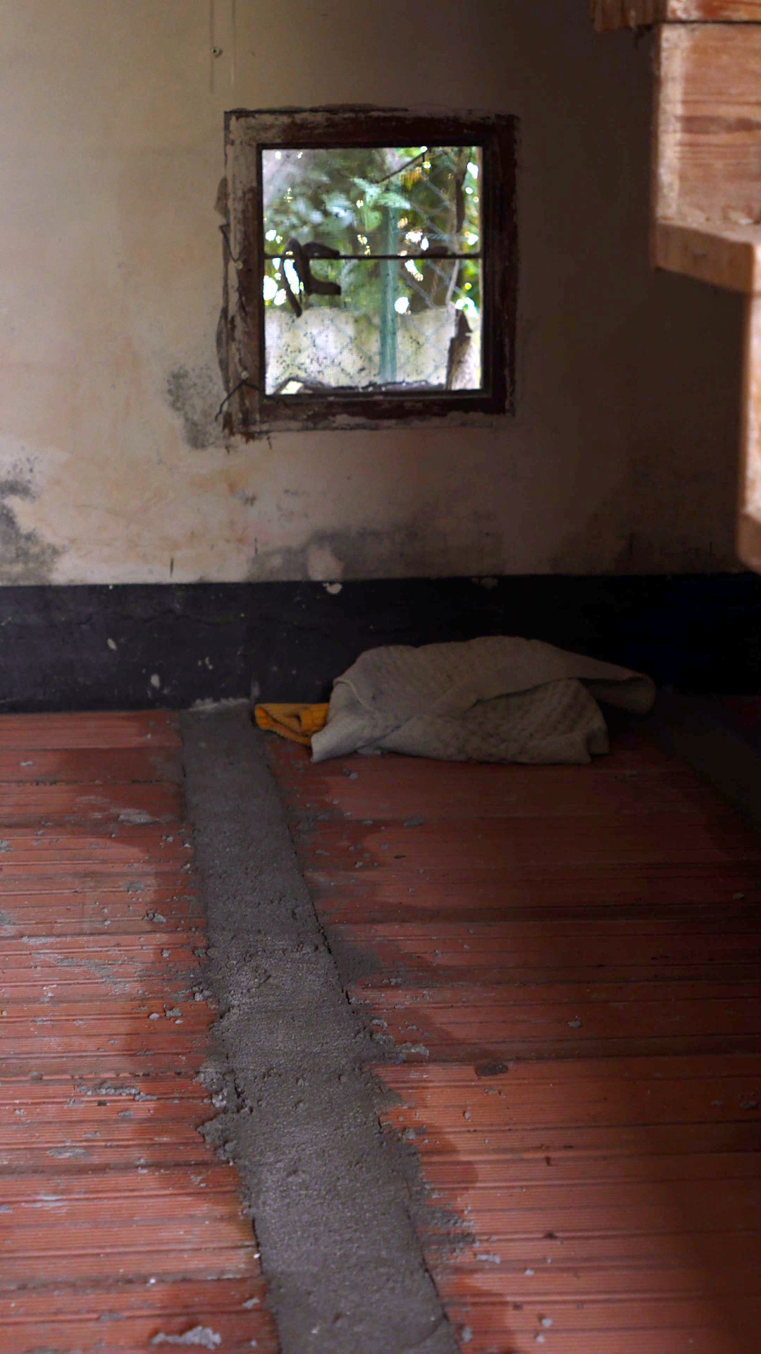 Il sottoscala prima della ristrutturazione a Pordenone, con il pavimento in mattoni sotto quota
