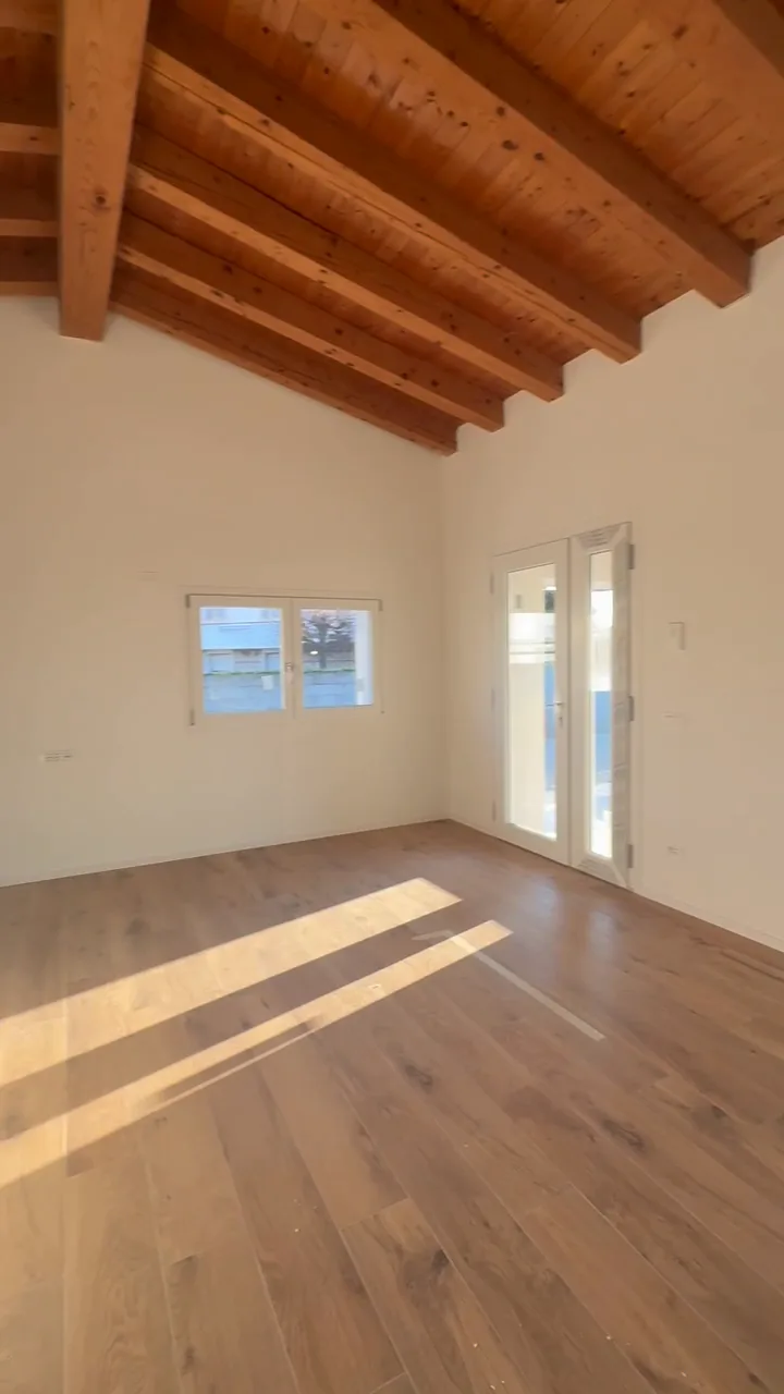 Casa finita: una camera sotto le travi a vista, con la portafinestra