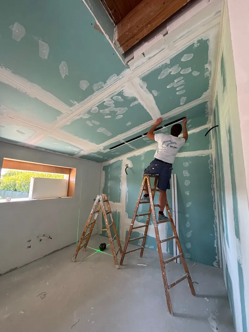 Durante i lavori: il controsoffitto in cartongesso, con un operaio di spalle sulla scala